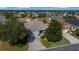 Aerial view of a single-story home showcasing mature trees, a well-manicured lawn, and neighborhood setting at 1828 Feliciana Ter, The Villages, FL 32162