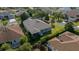 Aerial view of home with a screened lanai, mature trees, a landscaped backyard and neighborhood setting at 1828 Feliciana Ter, The Villages, FL 32162