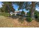 Well-maintained backyard featuring mature trees, a bridge, and lush landscaping at 1828 Feliciana Ter, The Villages, FL 32162