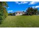 Well-maintained backyard featuring mature trees, a level lawn, and lush landscaping at 1828 Feliciana Ter, The Villages, FL 32162