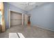 Bright bedroom with plush carpeting, closet, and a connecting hallway view at 1828 Feliciana Ter, The Villages, FL 32162