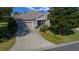 Charming single-story home featuring a screened front entry, attached garage, and well-manicured lawn at 1828 Feliciana Ter, The Villages, FL 32162