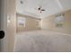 Spacious main bedroom with carpet, tray ceiling, large windows, and ceiling fan at 1828 Feliciana Ter, The Villages, FL 32162