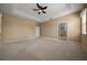Spacious main bedroom featuring tray ceilings, neutral carpet, and ceiling fan at 1828 Feliciana Ter, The Villages, FL 32162