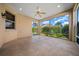 Covered patio with tile floor, ceiling fan, and screened openings with landscaped view at 1828 Feliciana Ter, The Villages, FL 32162