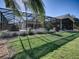 Home with a screened enclosure and grassy backyard at 1877 Quailey Ct, The Villages, FL 32163