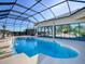 Inviting pool area with covered patio, fountain, and outdoor kitchen at 1877 Quailey Ct, The Villages, FL 32163