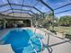 Lovely pool with a waterfall feature and screened enclosure at 1877 Quailey Ct, The Villages, FL 32163
