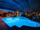 Stunning nighttime view of a screened pool and spa at 1877 Quailey Ct, The Villages, FL 32163