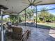 Spacious screened patio with wicker furniture and a view of the backyard at 1877 Quailey Ct, The Villages, FL 32163