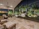 Evening view of a relaxing screened patio with wicker furniture at 1877 Quailey Ct, The Villages, FL 32163