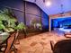 Night view of a relaxing screened patio with wicker furniture and a pool at 1877 Quailey Ct, The Villages, FL 32163