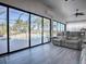 Sunroom with gray reclining sofas and view to the pool and garden at 1877 Quailey Ct, The Villages, FL 32163