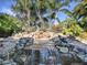 Serene multi-tiered waterfall surrounded by lush landscaping at 1877 Quailey Ct, The Villages, FL 32163