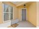 Inviting front porch with gray door, stylish light fixture, and large window at 2169 Smoaks St, The Villages, FL 32162
