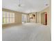Bright, spacious living room featuring neutral carpet, ample natural light, and an inviting view to the kitchen area at 2169 Smoaks St, The Villages, FL 32162