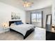 Bedroom with queen bed, large window, and city view art at 223 Knollwood Dr, Davenport, FL 33837