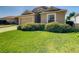 Tan house with a 2-car garage and a neat lawn at 223 Knollwood Dr, Davenport, FL 33837