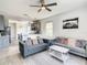 Open living room with gray couch and kitchen view at 223 Knollwood Dr, Davenport, FL 33837