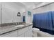 Bathroom with a granite countertop, a white vanity, a toilet, and an blue and white ombre shower curtain at 2676 Spider Lily Ct, Clermont, FL 34711