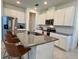 Bright kitchen featuring granite countertops, stainless steel appliances, an island with seating, and white cabinets at 2676 Spider Lily Ct, Clermont, FL 34711