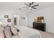 Spacious main bedroom with carpeted floors, walk-in closet, dresser with TV, and a ceiling fan at 2676 Spider Lily Ct, Clermont, FL 34711