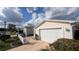 The house boasts a two-car garage, pristine vinyl siding, and a charming white picket fence at 3449 Roanoke St, The Villages, FL 32162