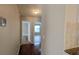 Hallway with wood flooring leading to the bedrooms, living area, and kitchen with granite countertops at 3449 Roanoke St, The Villages, FL 32162