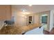Well-lit kitchen with granite countertops, a gas range, and seamless access to the dining area and garage at 3449 Roanoke St, The Villages, FL 32162