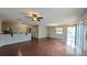 Bright living space with wood floors, a ceiling fan, and a seamless transition to the kitchen and dining area at 3449 Roanoke St, The Villages, FL 32162