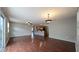 Open-concept living area with gleaming wood floors, fan, and a seamlessly connected kitchen with bar seating at 3449 Roanoke St, The Villages, FL 32162