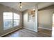 Bright living room with wood floors, large window, stylish light fixture, and open doorway to the bathroom at 3639 Bream Cir, Fruitland Park, FL 34731