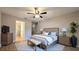 The staged main bedroom includes a queen bed and sitting bench with wood floors at 3639 Bream Cir, Fruitland Park, FL 34731