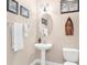 Guest bathroom with pedestal sink, toilet, and decorative accents at 38626 Lakeview Walk, Lady Lake, FL 32159