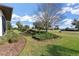 Landscaped front yard with mature shrubs and trees, showcasing curb appeal at 38626 Lakeview Walk, Lady Lake, FL 32159