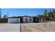 Modern single-story home featuring a two-car garage, black window trim, and a stylish entryway portico at 39817 Forest Dr, Eustis, FL 32736