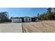 Modern home with white exterior and black trim, featuring a concrete driveway and desert-style landscaping at 39817 Forest Dr, Eustis, FL 32736