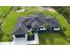 Aerial view of a modern home with a dark roof, lush green lawn, landscaping and white accents at 42157 Tamarac St, Eustis, FL 32736