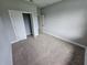 Carpeted bedroom with neutral walls, modern doors, and a view of the outdoors at 42157 Tamarac St, Eustis, FL 32736