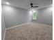 Spacious bedroom featuring plush carpet, a window with a view, and a modern ceiling fan at 42157 Tamarac St, Eustis, FL 32736