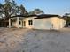 Beautiful new home exterior features a covered patio and white stucco walls at 42157 Tamarac St, Eustis, FL 32736