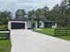 Striking single-story home with black accents, well-manicured lawn, and a spacious driveway at 42157 Tamarac St, Eustis, FL 32736
