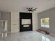 Open living room featuring a fireplace, shelving, ceiling fan, and marble floors at 42157 Tamarac St, Eustis, FL 32736