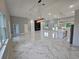 Bright, open-concept living space featuring modern lighting fixtures and marble-look flooring at 42157 Tamarac St, Eustis, FL 32736