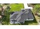This modern home boasts a dark roof, covered patio with trellis, and green grass at 42200 Chinaberry St, Eustis, FL 32736