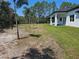 Spacious backyard with mature trees, partial lawn and covered patio at 42200 Chinaberry St, Eustis, FL 32736