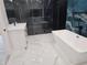 Modern bathroom featuring marble floors, soaking tub, glass shower, and white vanity at 42200 Chinaberry St, Eustis, FL 32736