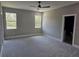 Empty bedroom with plush carpeting, neutral walls, white trim, and bright, natural light at 42200 Chinaberry St, Eustis, FL 32736