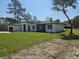 Charming single-story home with lush green lawn and sleek, modern architectural details at 42200 Chinaberry St, Eustis, FL 32736