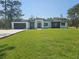 Modern home featuring a well manicured lawn, two car garage, and a striking front door at 42200 Chinaberry St, Eustis, FL 32736